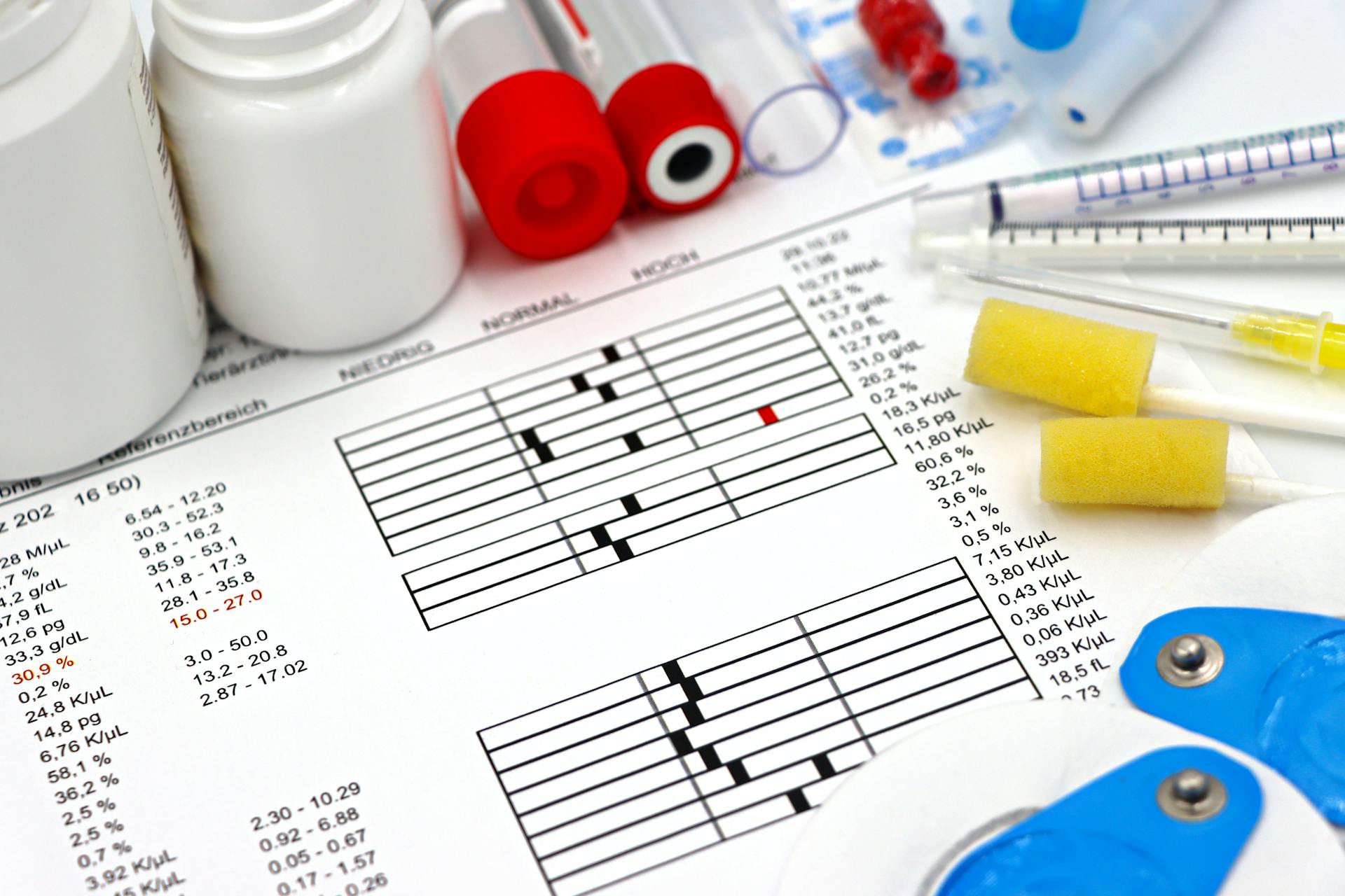 Arrangement of medical equipment, lab tests, and health data on a clinical table.