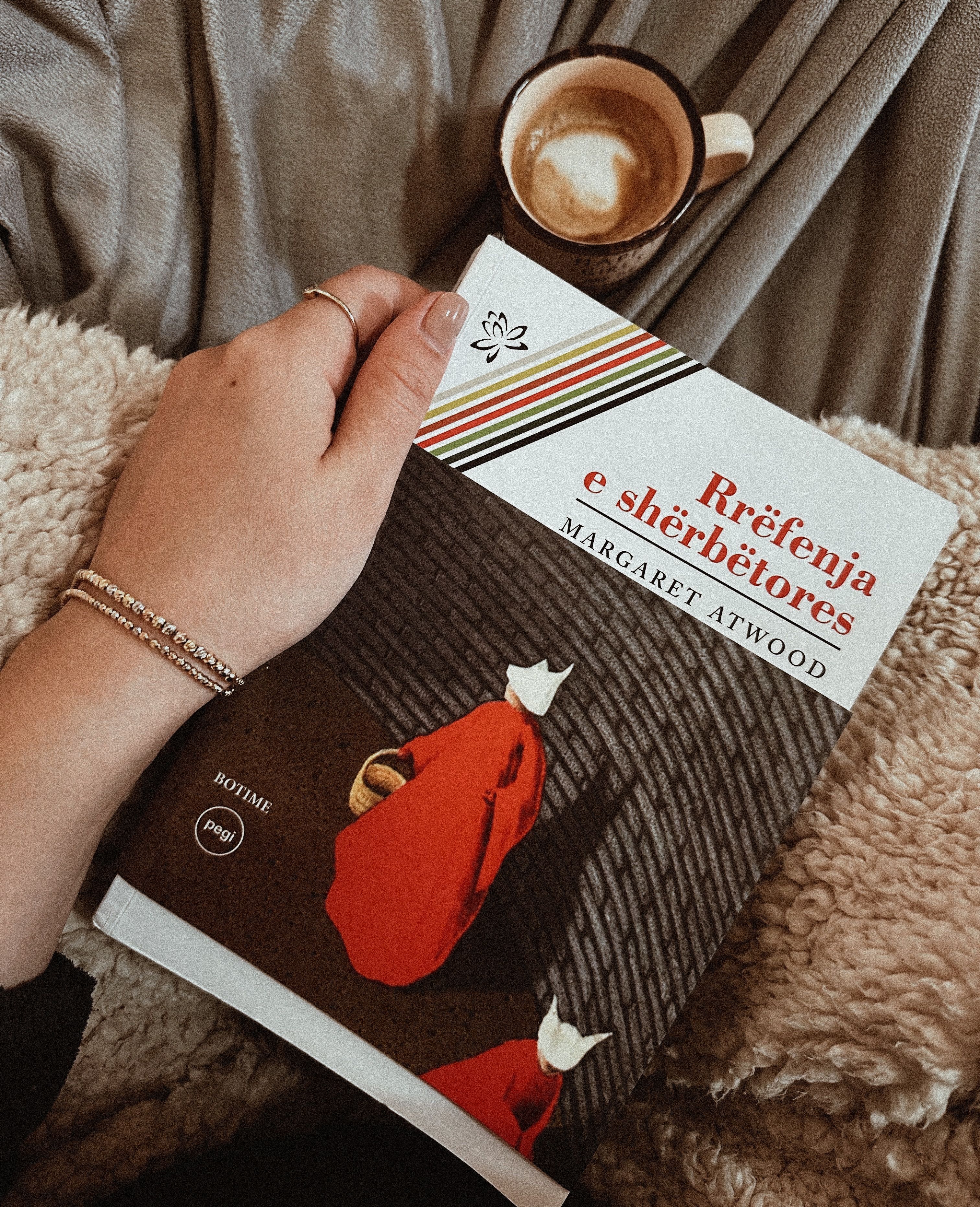 Enjoy a cozy moment with a book and coffee in a warm, relaxing setting.