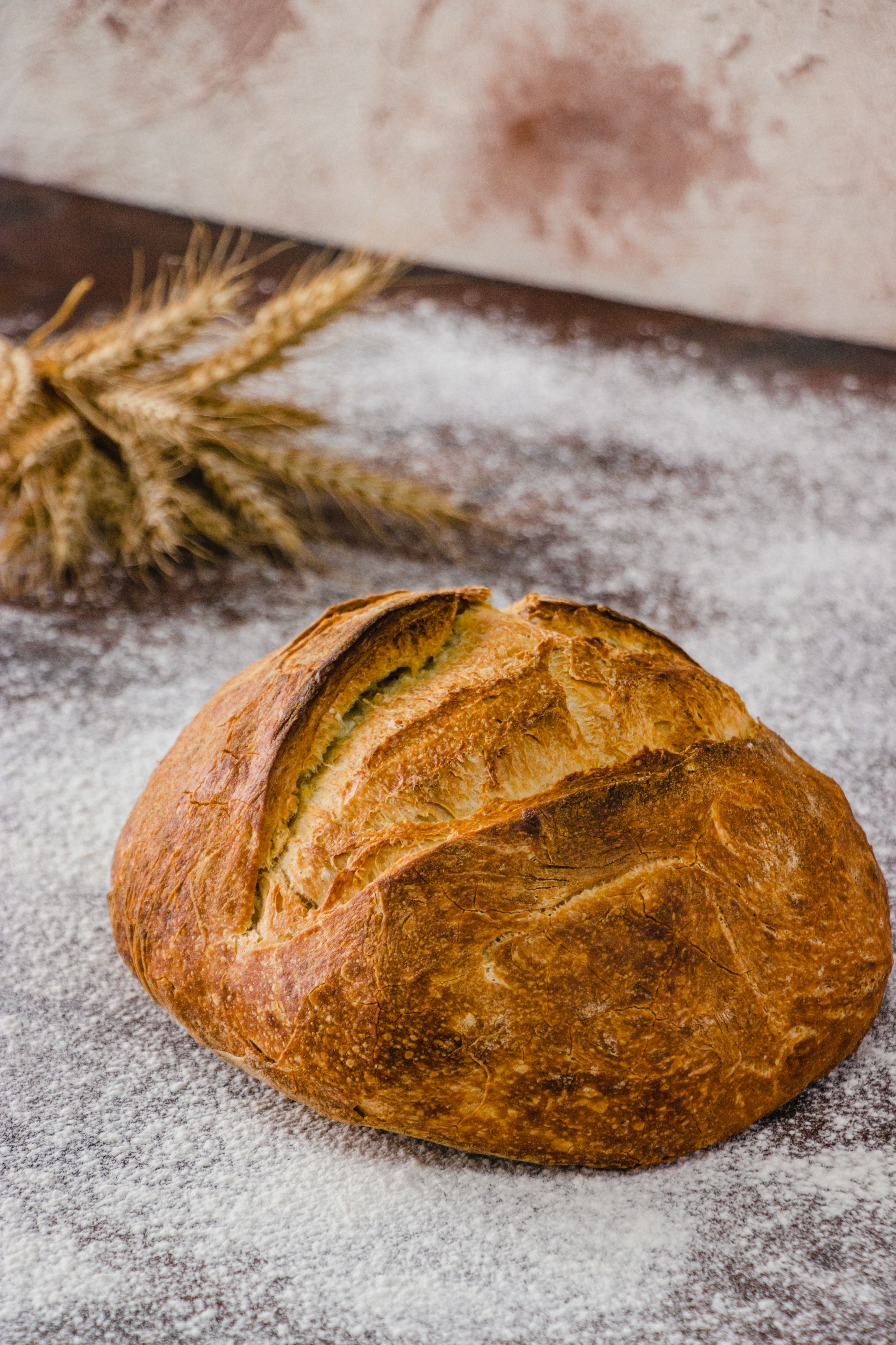 Rustic Artisan Bread with Wheat on Wooden Table · Free Stock Photo