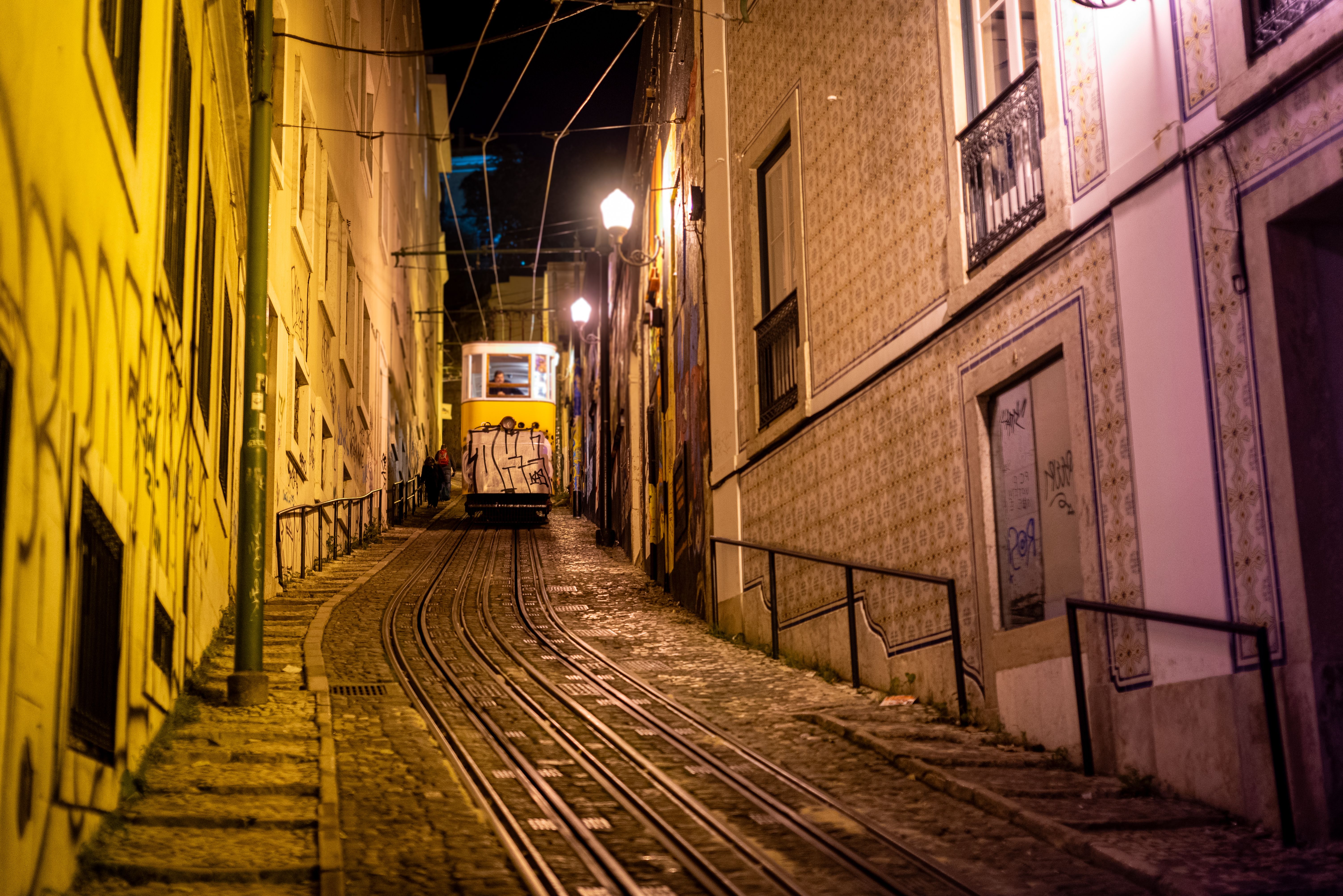 A night scene of the famous tram navigating steep tracks in Lisbon, Portugal.