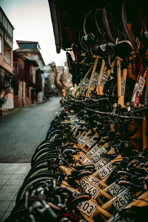 Free A vibrant row of yellow rental bicycles lines a street on a scenic Istanbul island, offering a serene urban landscape. Stock Photo