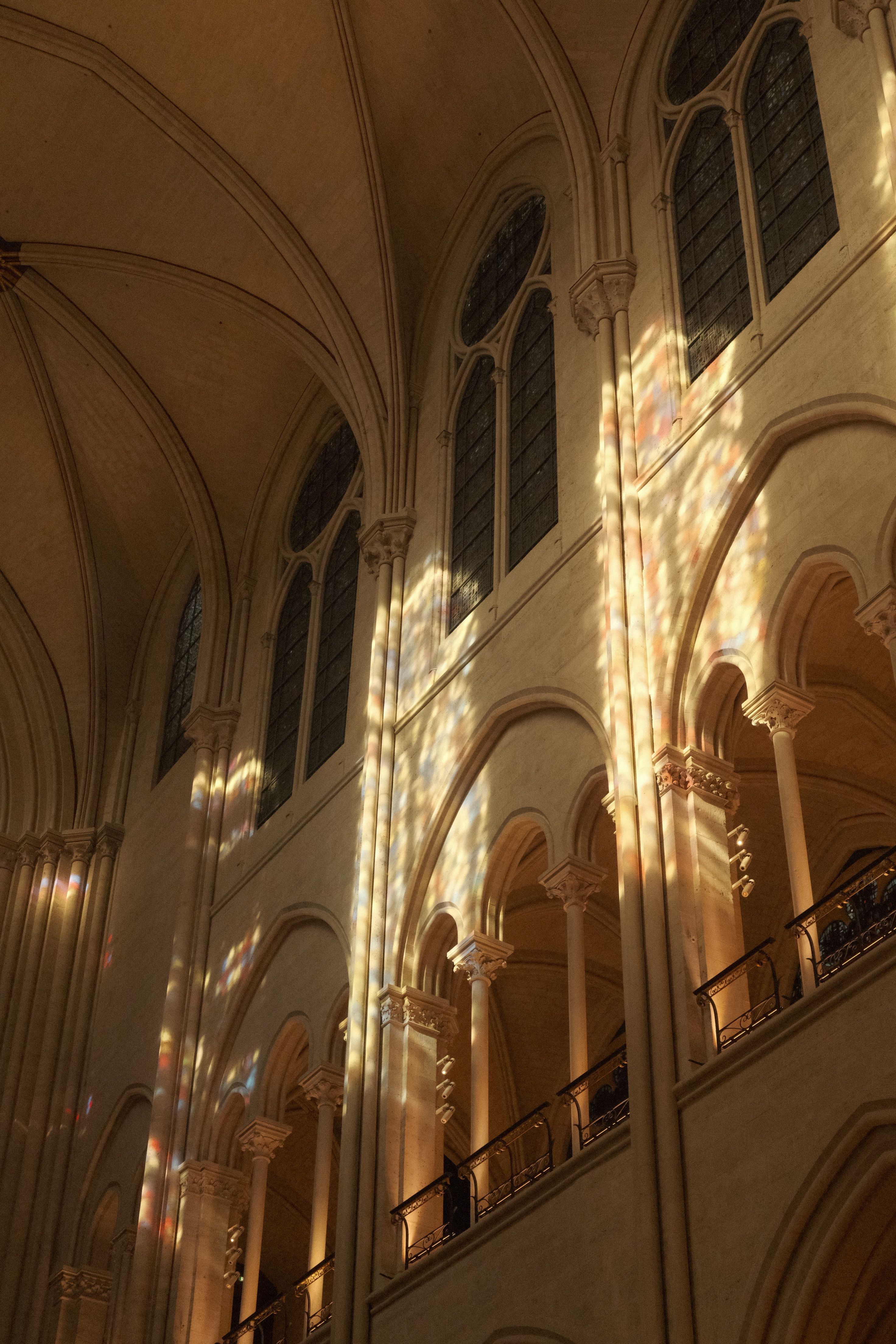 Sunlight creates colorful reflections through gothic cathedral windows.