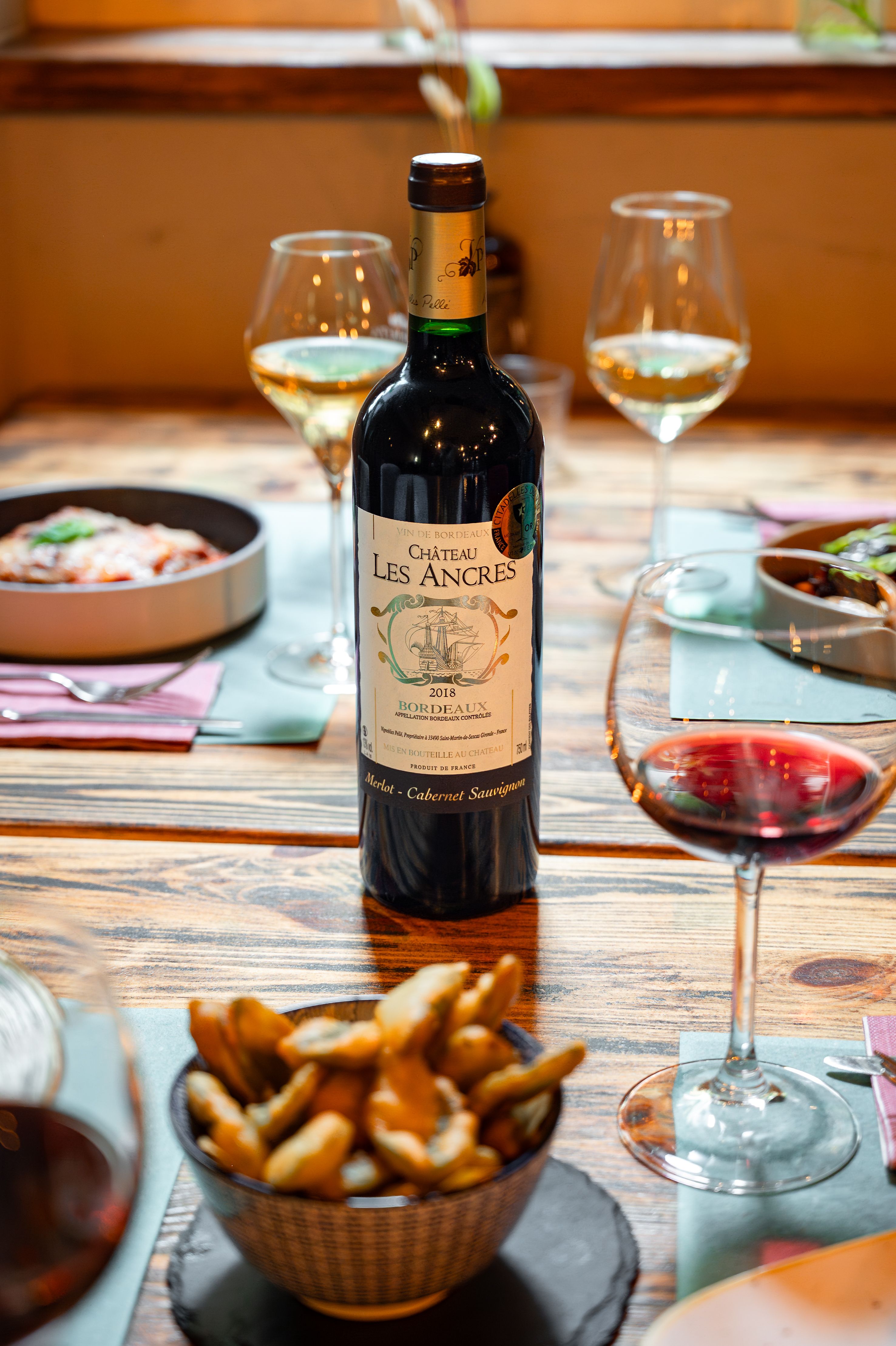 Bordeaux wine bottle with elegant dining setup in Brescia, Italy.