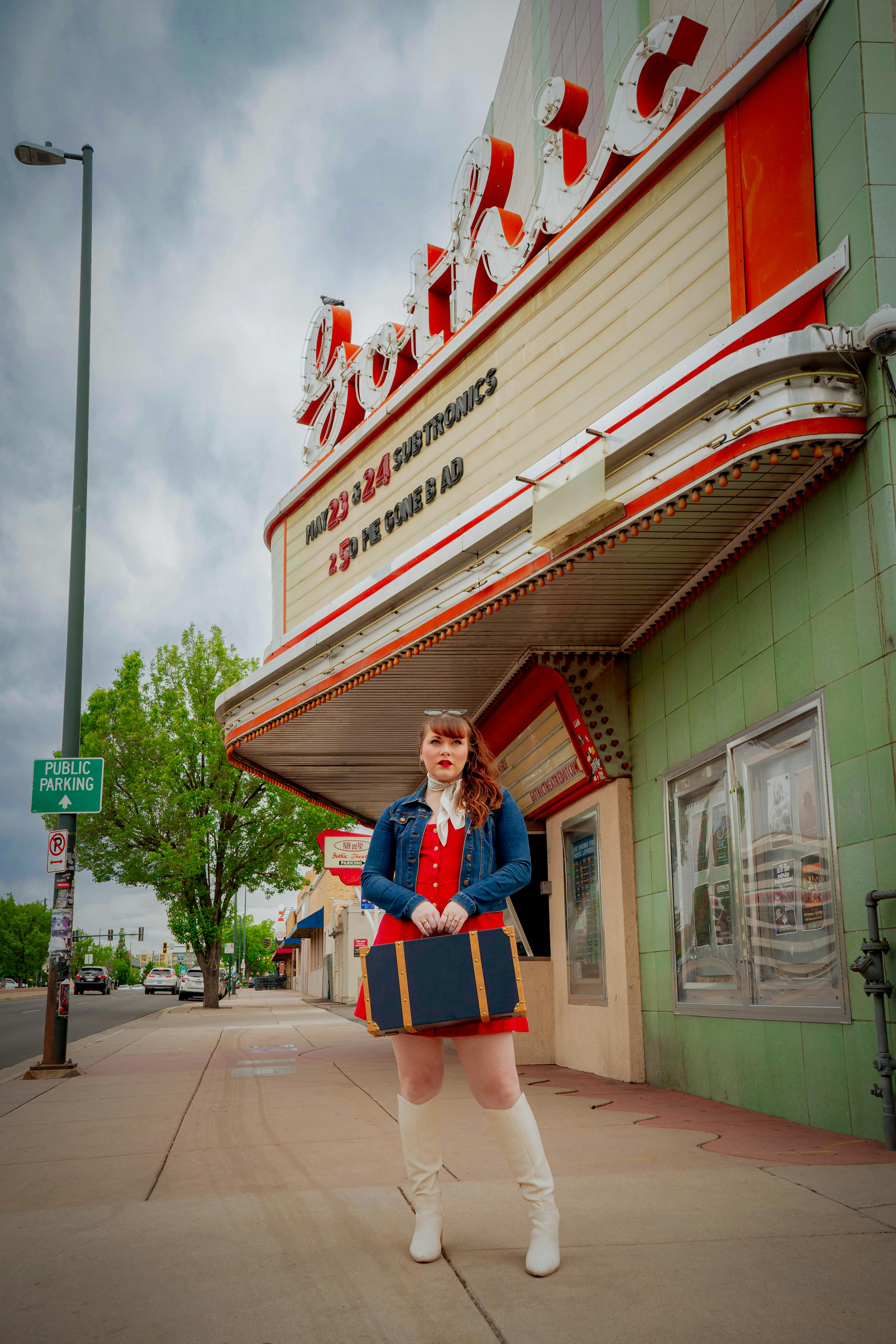 Free A stylish young woman in vintage attire poses outside the Gothic Theatre, Englewood. Stock Photo