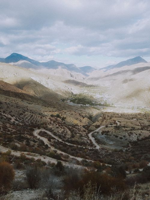 Free Dramatic view of a sprawling mountain landscape with winding paths, captured on a cloudy day. Stock Photo