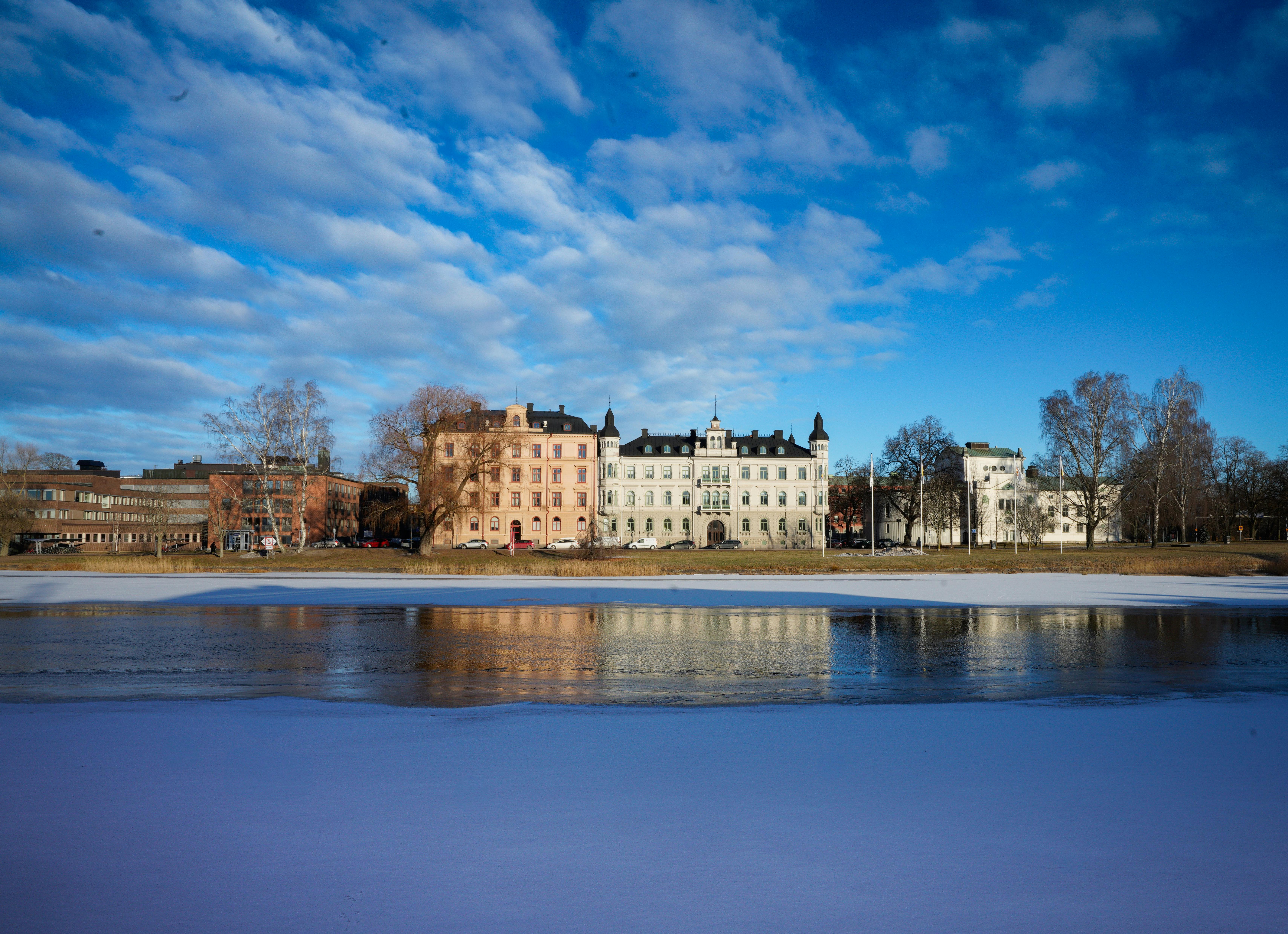 Winter view of historical buildings reflected on frozen water in Karlstad, Sweden.