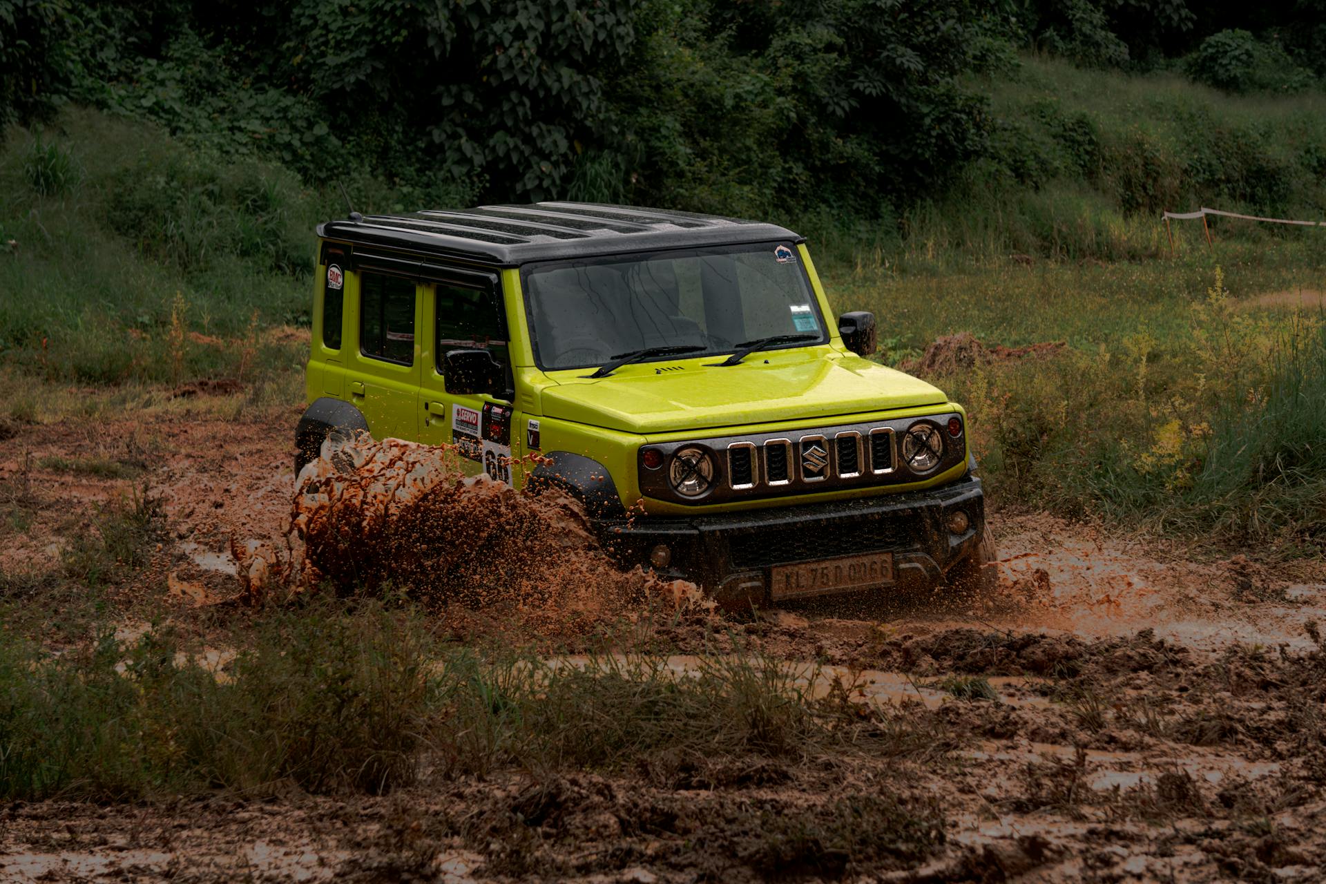 Vibrant lime SUV powers through muddy off-road trail, showcasing adventure and rugged capability.