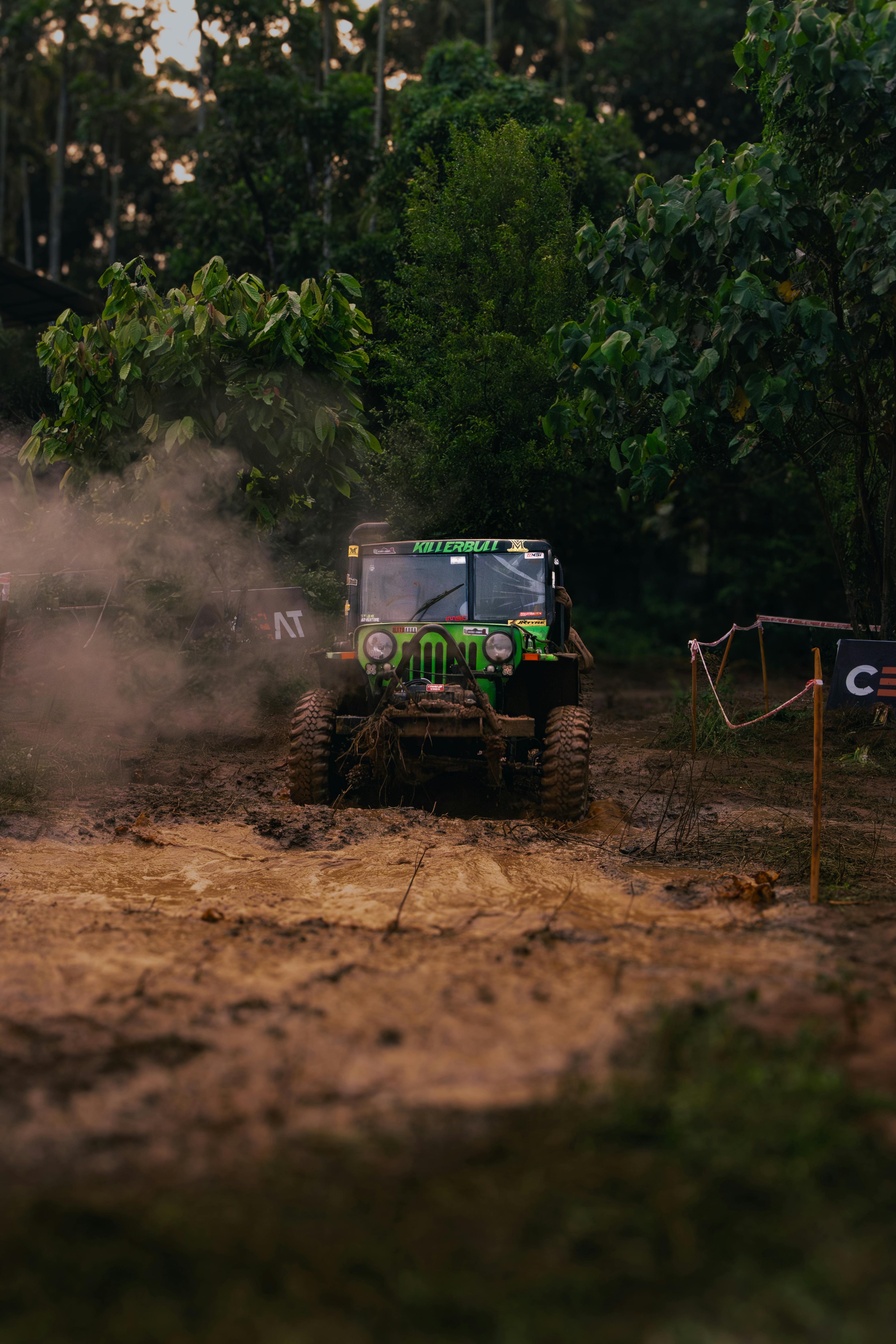 A rugged jeep navigating through a muddy forest path, showcasing off-road adventure.