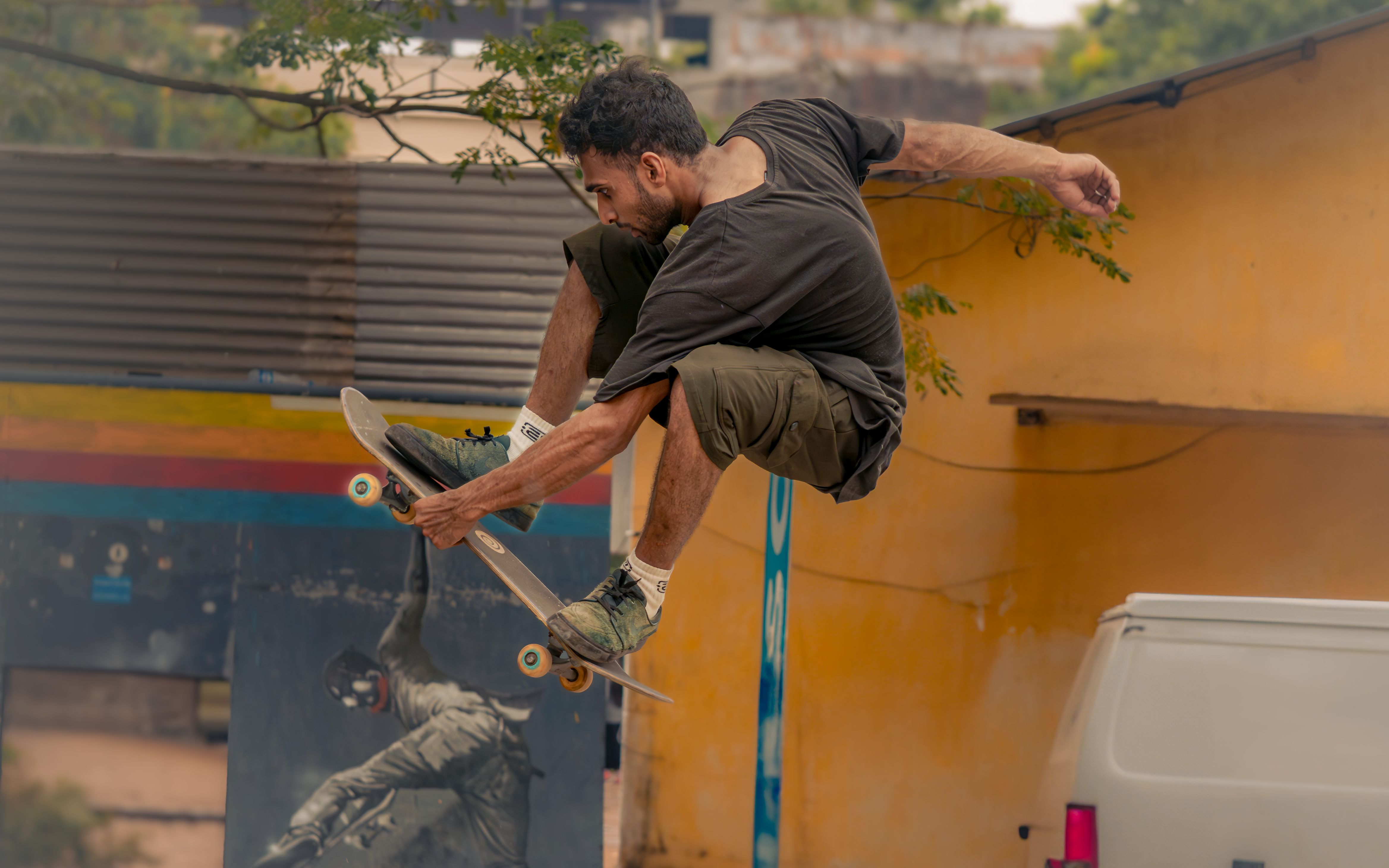 Skateboarder performing a high jump trick in a colorful urban environment.. skateboarder, performing, high