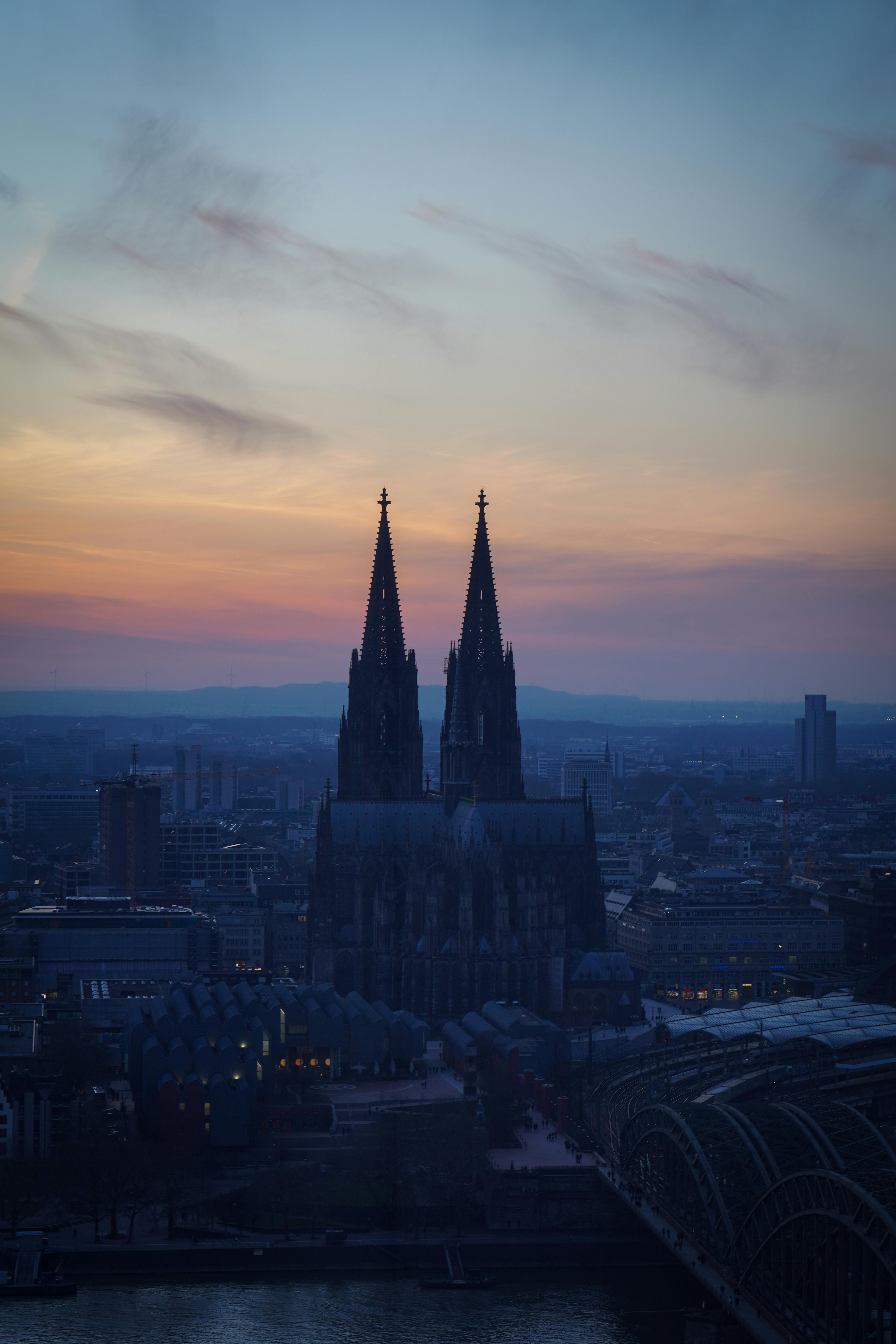 Stunning view of Cologne Cathedral silhouetted against a colorful sunset sky.