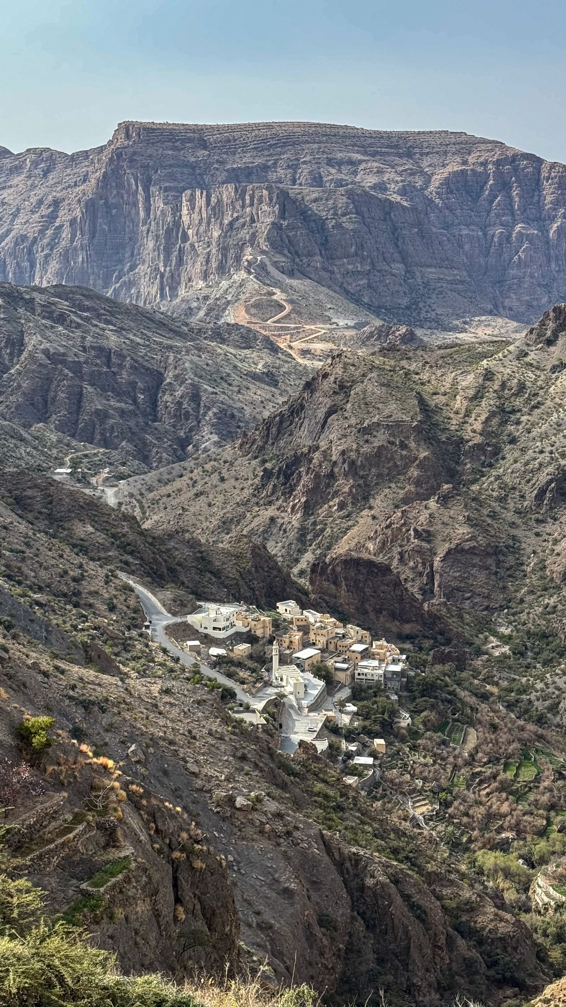 Scenic view of a small village nestled in rugged mountains, capturing natural serenity.