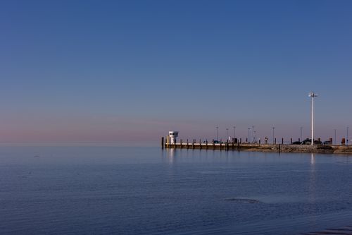 Free Peaceful view of Dagebüll harbor in morning light, with calm sea and clear sky. Stock Photo