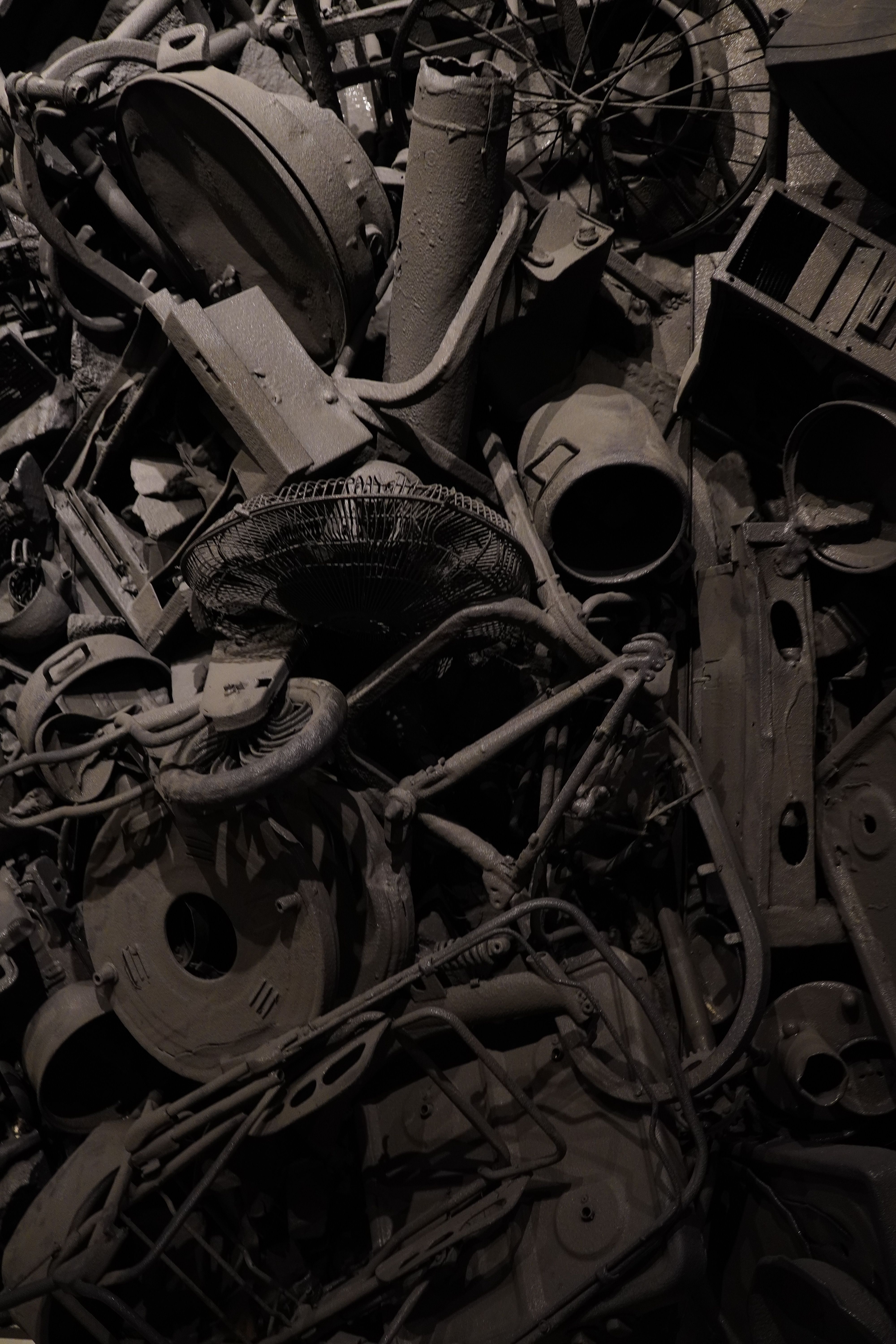 A collection of salvaged materials, including reclaimed wood, scrap metal, shipping container segments, and textile waste, arranged artistically to showcase their potential for upcycling.