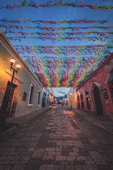 Vibrant street decorations hanging over a cobblestone street in Oaxaca, Mexico.