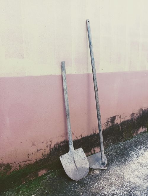 Free An old shovel and hoe leaning against a textured wall in Brazil. Stock Photo