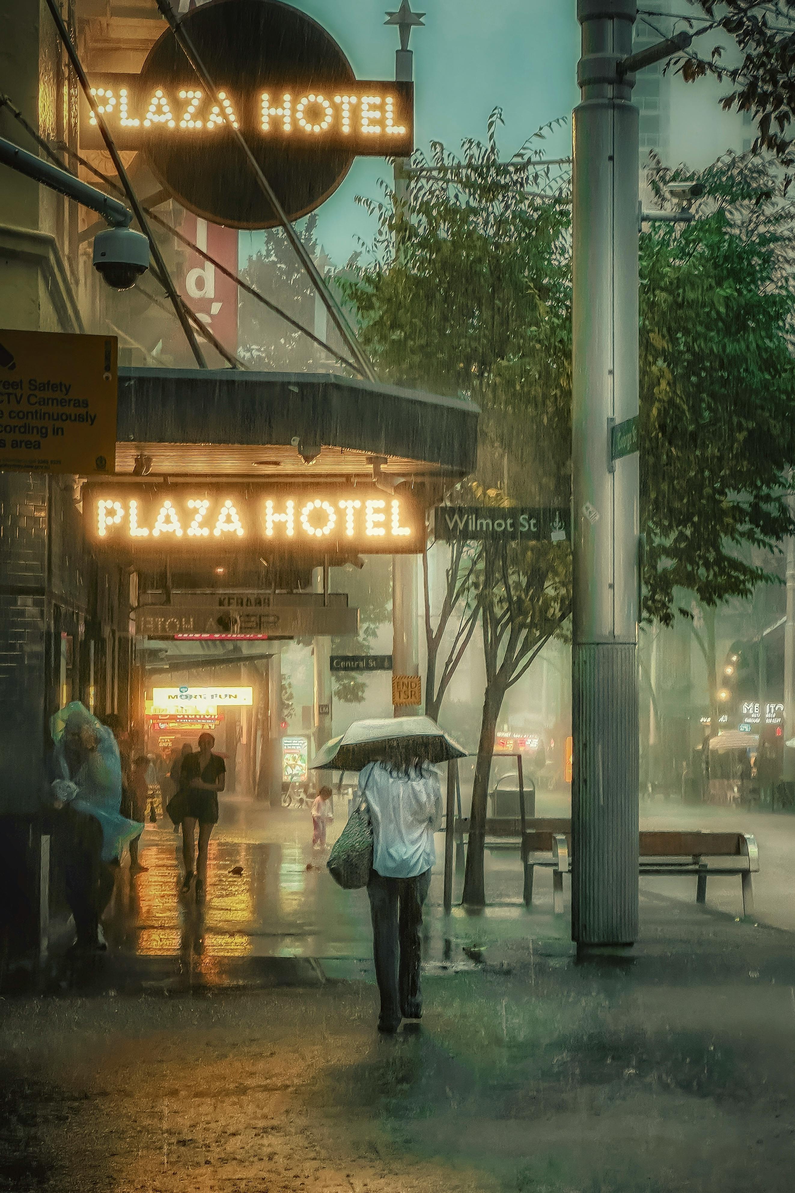 A rainy evening in Sydney's CBD with pedestrians under umbrellas, outside the Plaza Hotel.