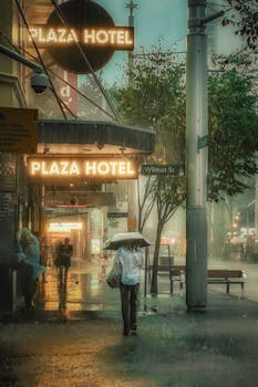 A rainy evening in Sydney's CBD with pedestrians under umbrellas, outside the Plaza Hotel.