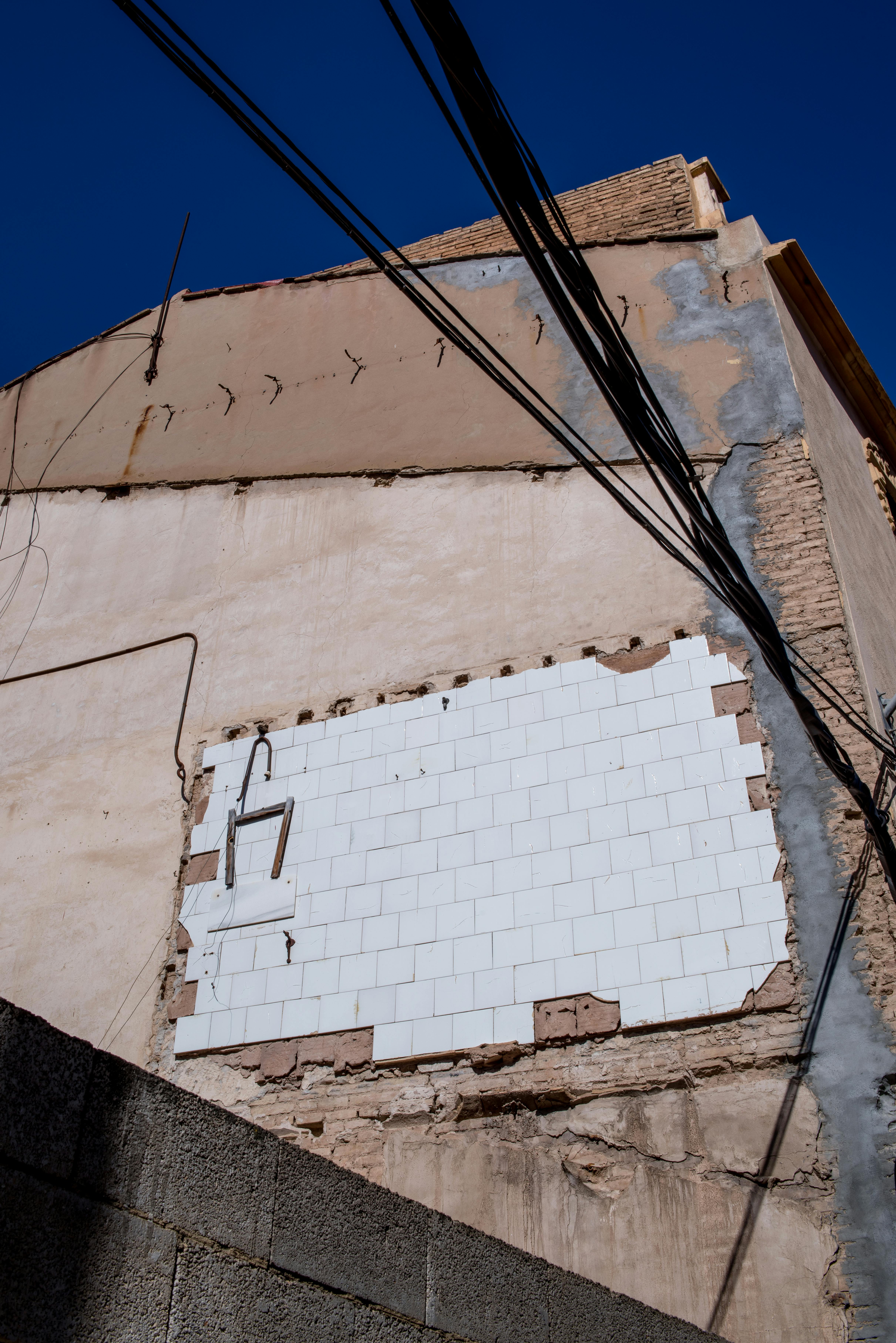 urban decay crumbling building facade with wires