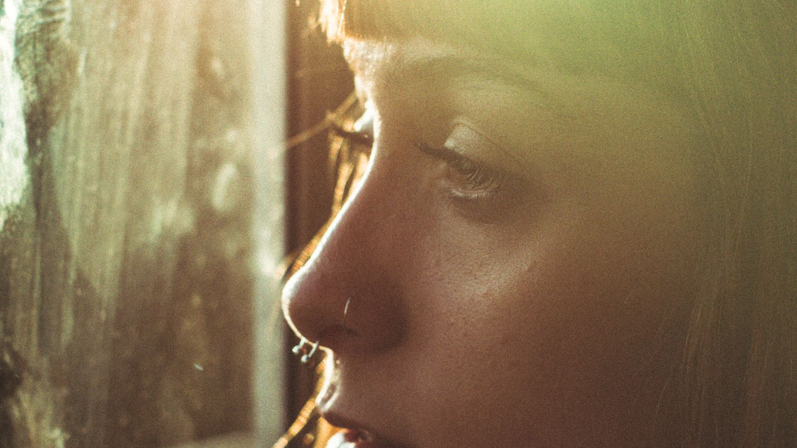A woman looking through a sunlit window