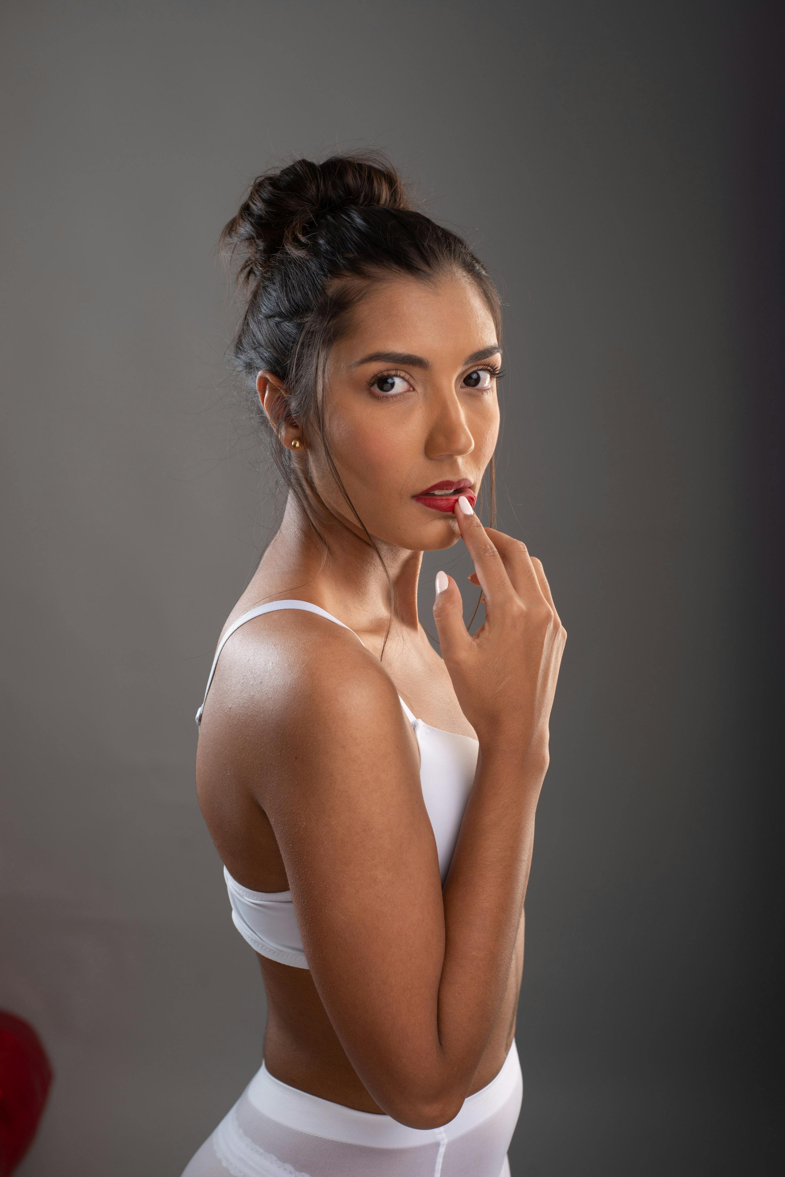 Gratis Ritratto di una donna elegante in lingerie bianca che posa con eleganza in un ambiente interno. Foto a disposizione