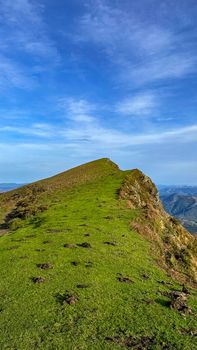Scenic view of a verdant mountain ridge ascending into a clear blue sky, perfect for nature enthusiasts.