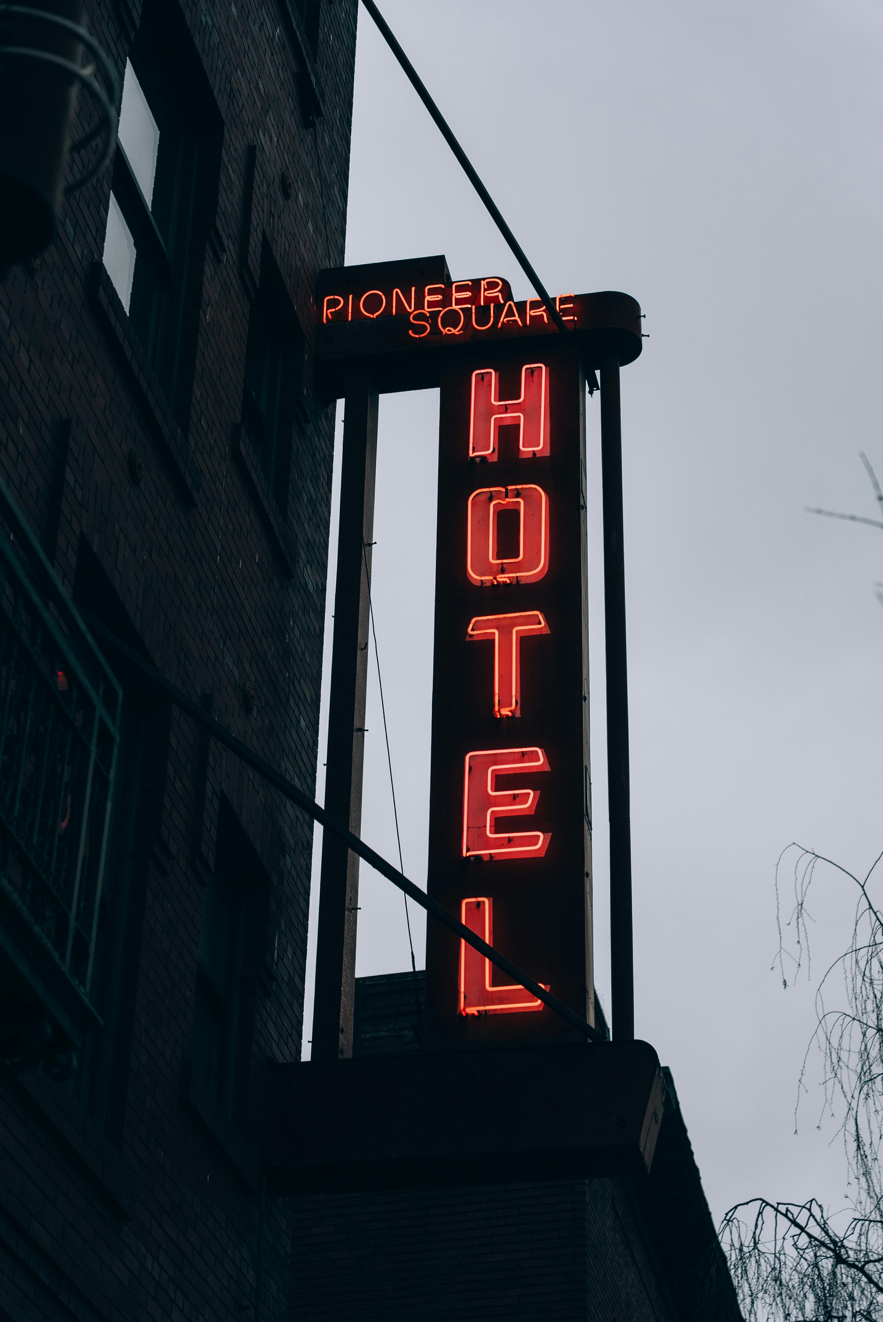 Free A neon hotel sign in Pioneer Square, Seattle, exudes urban moody vibes. Stock Photo