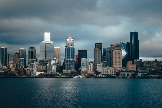 Dramatic skyline of Seattle cityscape with moody clouds over Puget Sound.