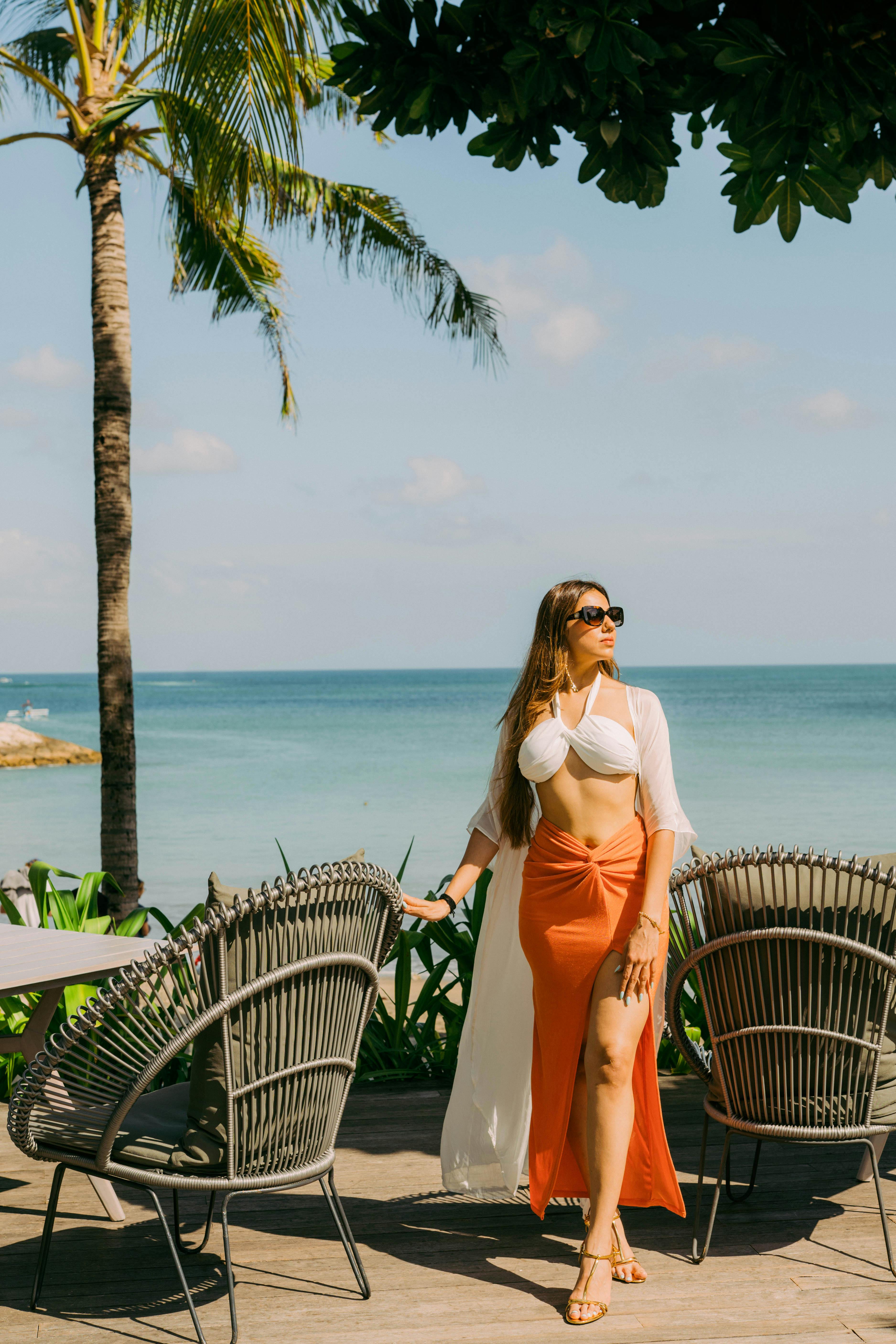 bezplatná Elegantní model pózující u oceánu pod palmami na Bali s tropickými vibracemi. Základová fotografie