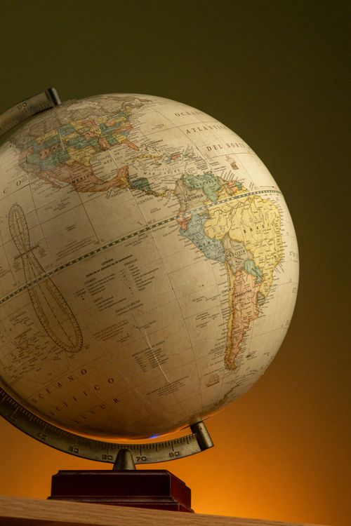Free An antique globe showcasing detailed maps of North and South America with warm lighting. Stock Photo