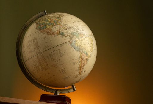 A vintage globe illuminated with warm lighting, showcasing the Americas. 30792659