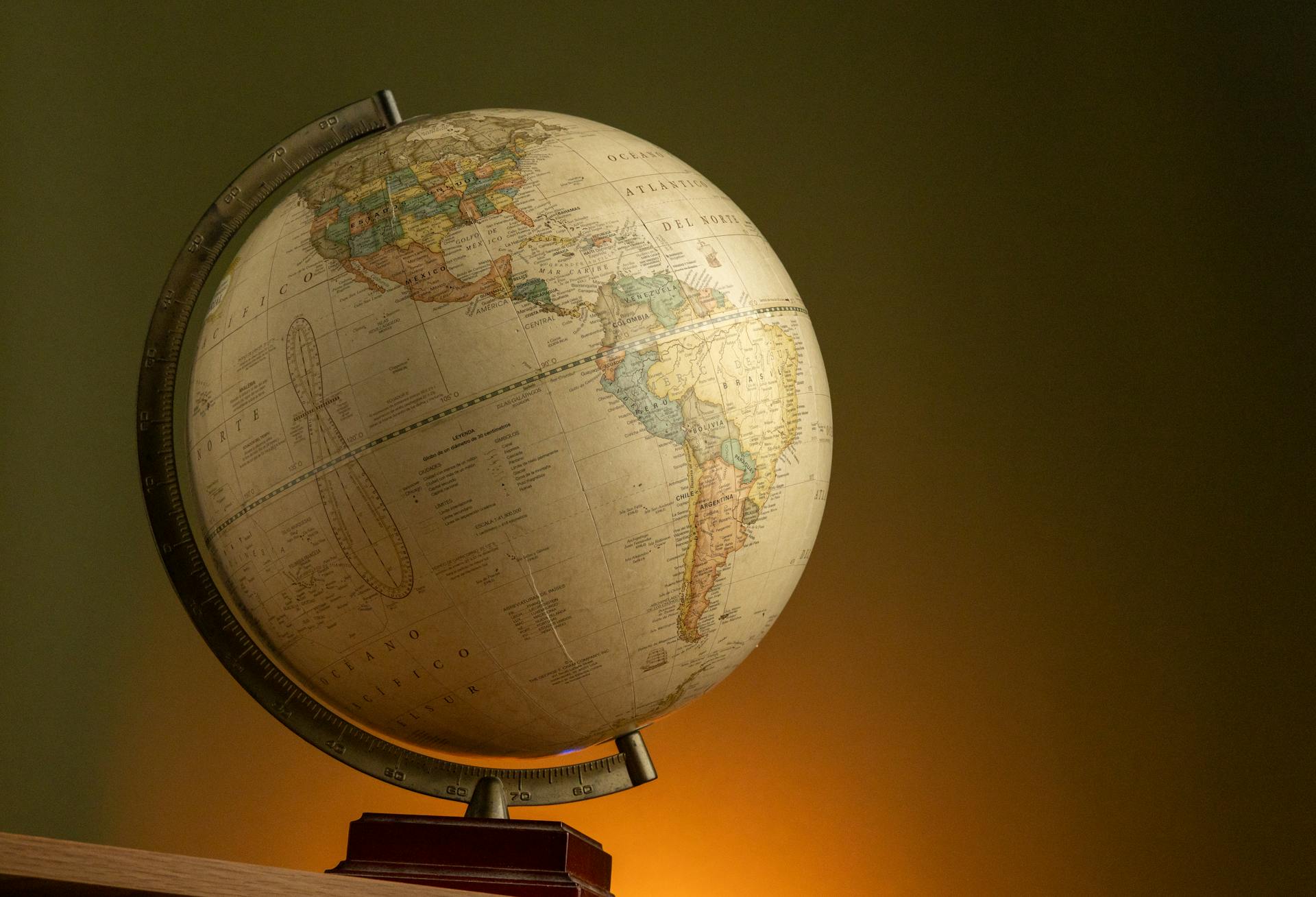 A vintage globe illuminated with warm lighting, showcasing the Americas.