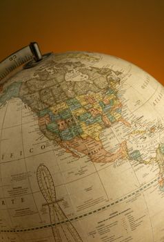A close-up of a vintage globe highlighting North America, captured with warm lighting. 30792662