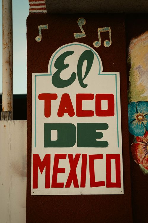Free Vibrant sign reading 'El Taco De Mexico' with musical notes adds charm to an exterior wall. Stock Photo