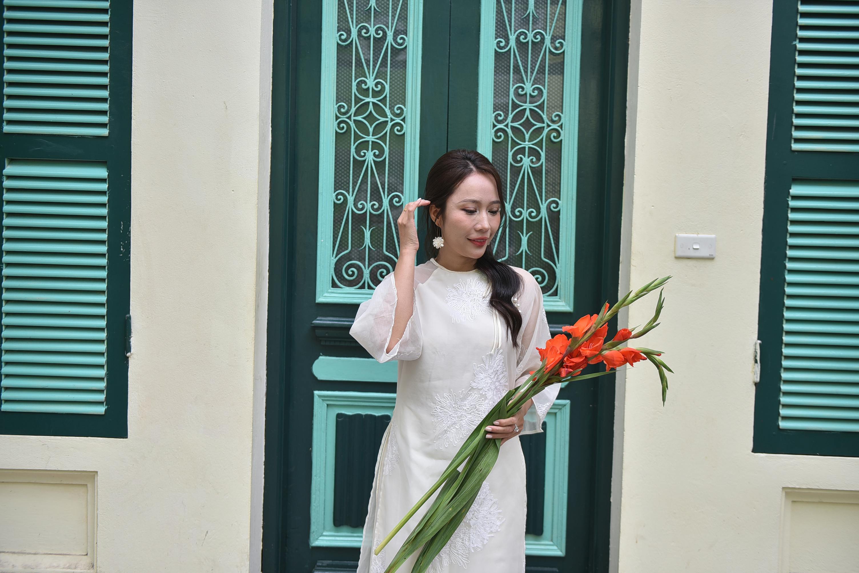 woman holding gladiolus flowers by elegant doorway