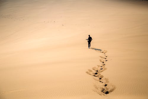 Человек, идущий по песчаным дюнам