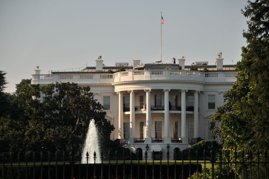 The stately White House with its iconic architecture surrounded by lush greenery, featuring a majestic fountain.