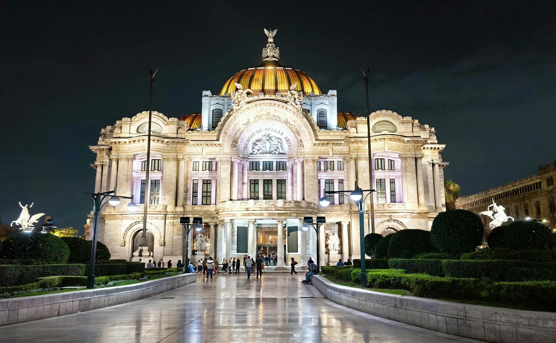 Gorgeous evening view of the illuminated Palacio de Bellas Artes in Mexico City, a cultural landmark.