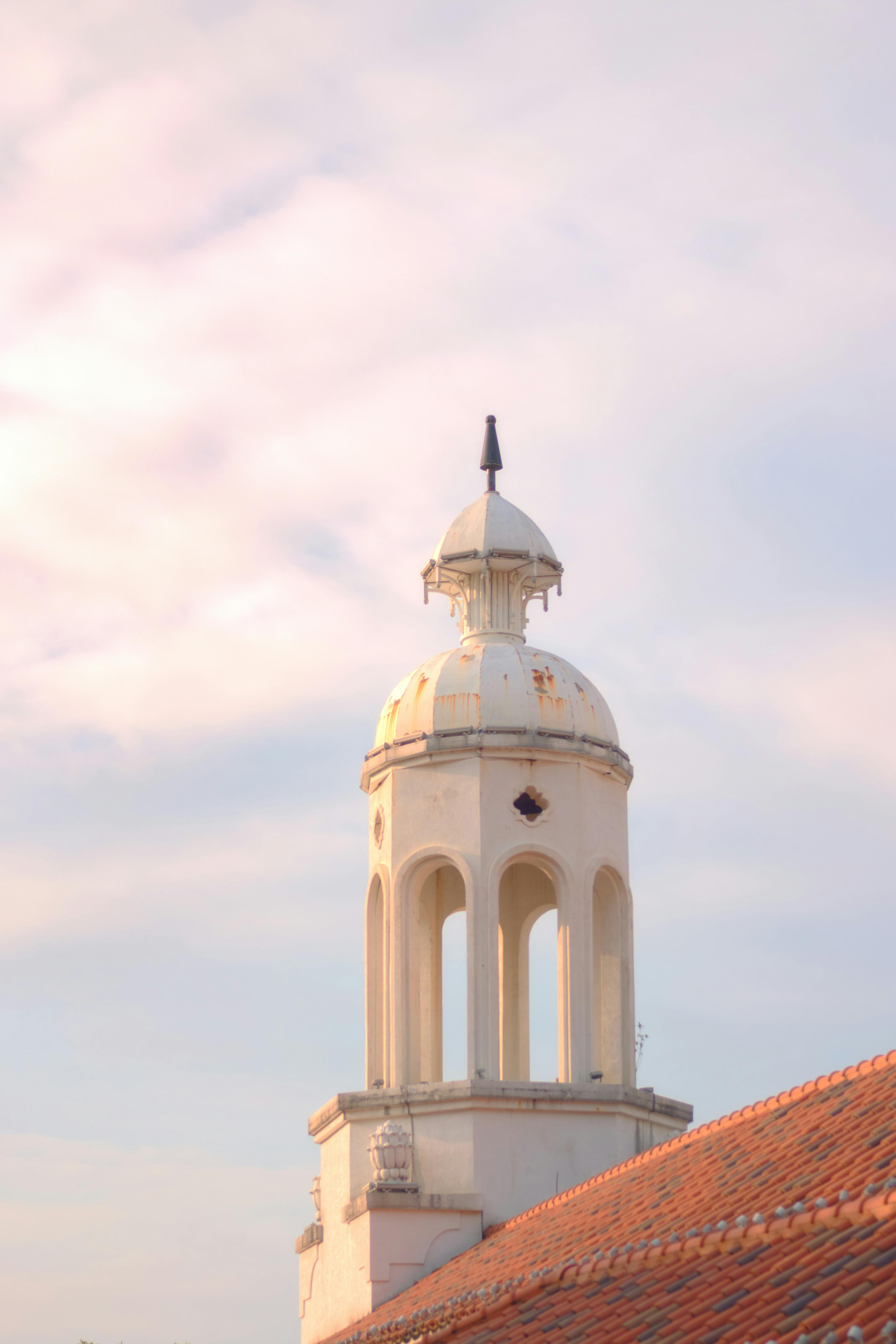 A picturesque view of a historic tower in Meizhou, China, bathed in warm sunset light.