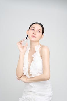 Elegant woman showcasing skincare product in a studio setting.