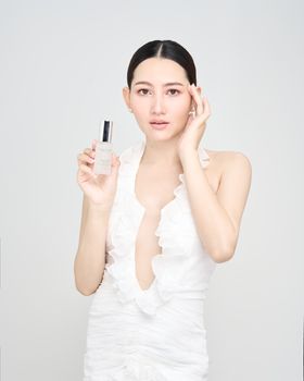 Portrait of an elegant model showcasing a skincare product, emphasizing clear skin and beauty.