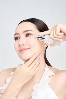 A woman applying skincare serum to her face for a glowing complexion.