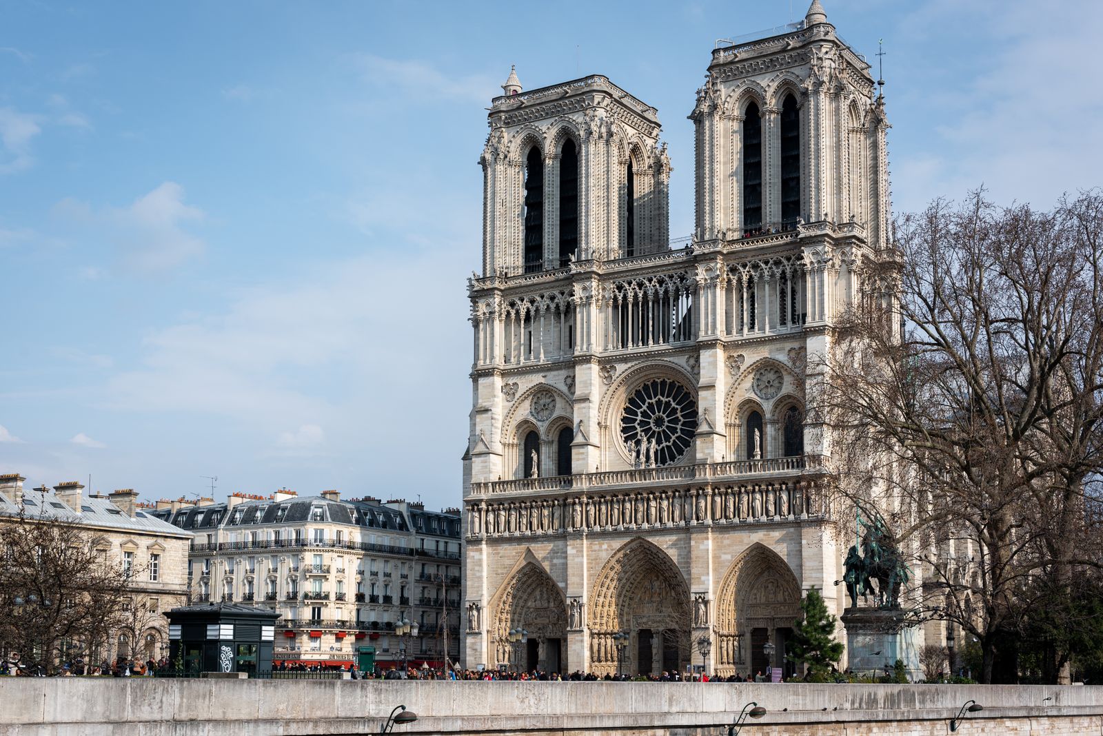 View of Notre Dame Cathedral in Paris, showcasing its Gothic architecture against a clear sky.