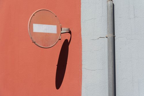 Free Colorful urban wall with a traffic sign casting a shadow. Stock Photo