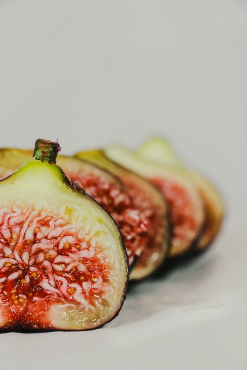Gratis Primo piano dettagliato di fichi tagliati a fette che mostrano colori e consistenza vivaci su uno sfondo neutro. Foto a disposizione