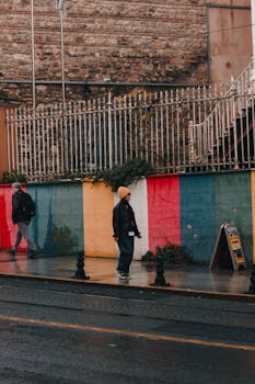 A vibrant street scene in Istanbul featuring colorful walls and pedestrians on a rainy day.
