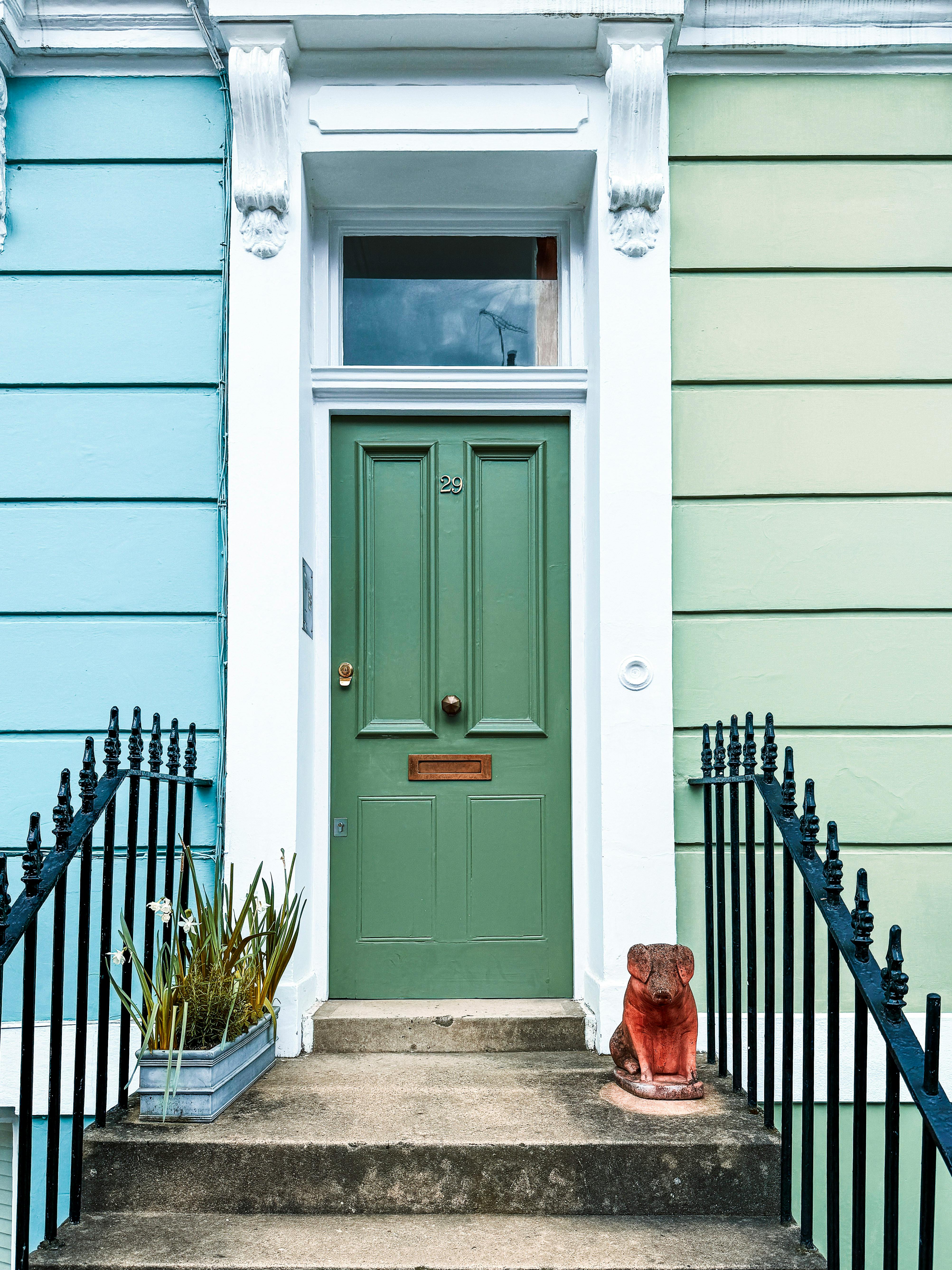 Elegant green door with vibrant pastel walls in a picturesque London street.