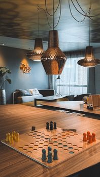 Cozy living room interior with pendant lights and board game setup.