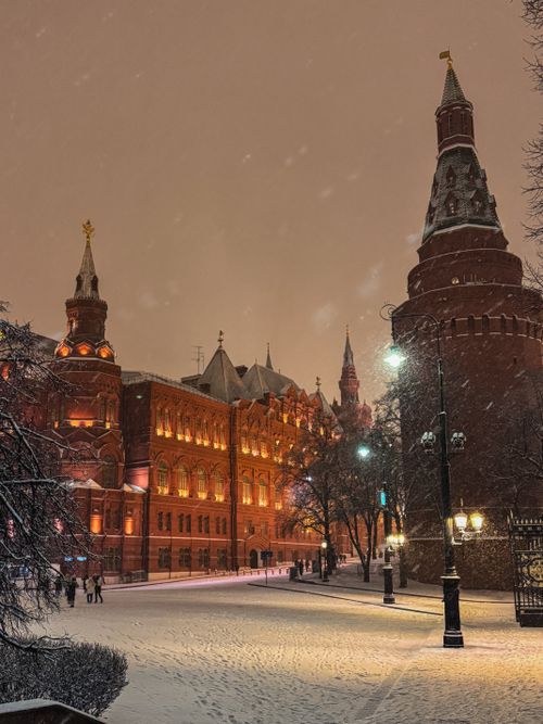 Free Snow falling at night in Red Square, capturing the illuminated Kremlin towers and buildings in Moscow. Stock Photo