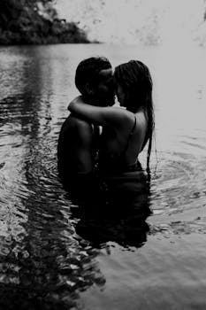 一对夫妇在宁静的泻湖里温柔相拥，黑白摄影更添亲密
