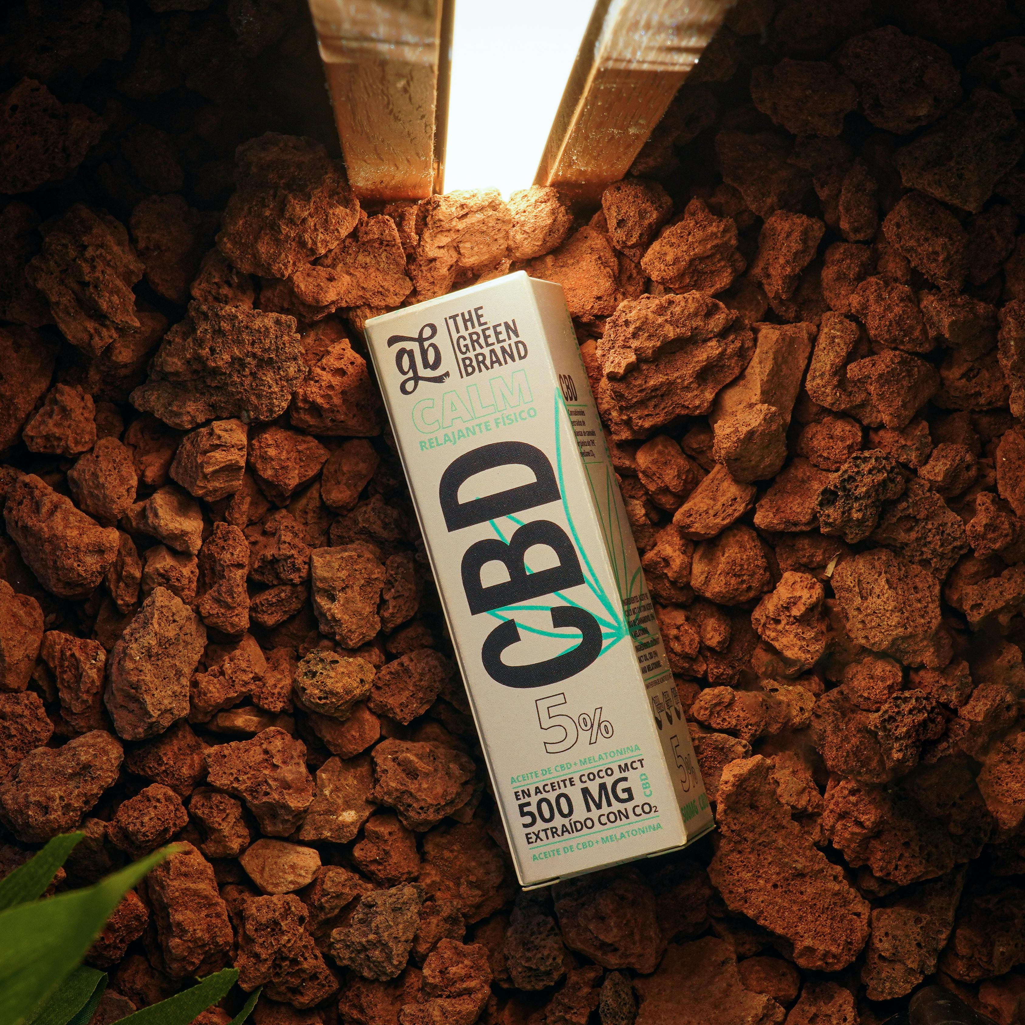 Unlock the Power of MCT Powder 70: A Comprehensive Guide 1 CBD oil product package on textured rocky surface with warm lighting.